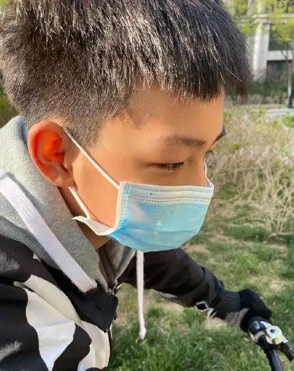 出12岁元宝的骑行照片,母亲视角下的元宝剪了利落的短发,虽然戴着口罩