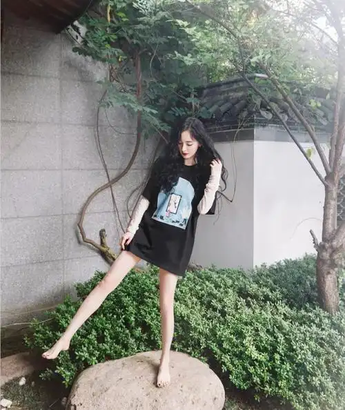 杨幂的这身夏天的穿搭是经典的"下衣失踪"风格,上身一件宽大的黑色t恤
