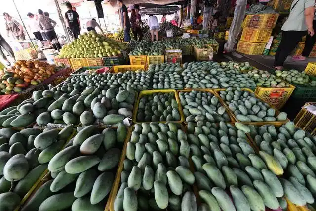 农副产品综合批发市场,人们在交易刚收获的芒果(2021年7月1日摄)