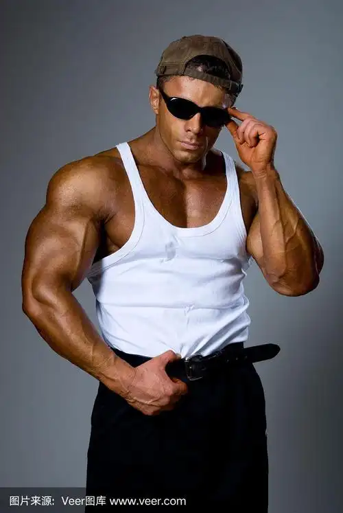 英俊的男性健美训练在墨镜盯着