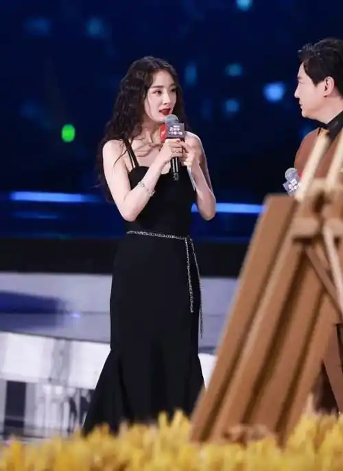 也更加具备减龄效果,中分款式的"泰迪卷",配合上黑色吊带鱼尾裙,细腰