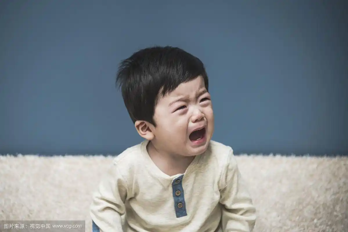 在地毯上哭泣的小男孩