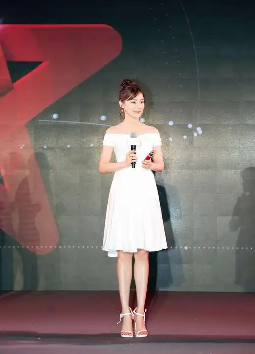 袁姗姗身穿这一条白色的连衣短裙,一字肩的设计尽显性感时尚,脚穿一双