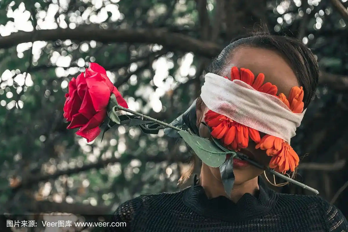 她眼睛上缠着红花,嘴里叼着一朵玫瑰