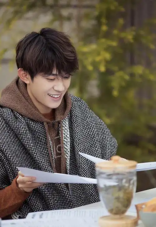 易烊千玺穿复古连帽马甲 梨涡浅笑文艺范十足