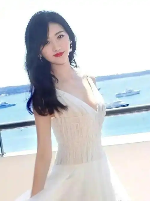 景甜穿着一套白色的吊带露肩长裙,胸襟是深v设计,微露景甜的傲人胸部