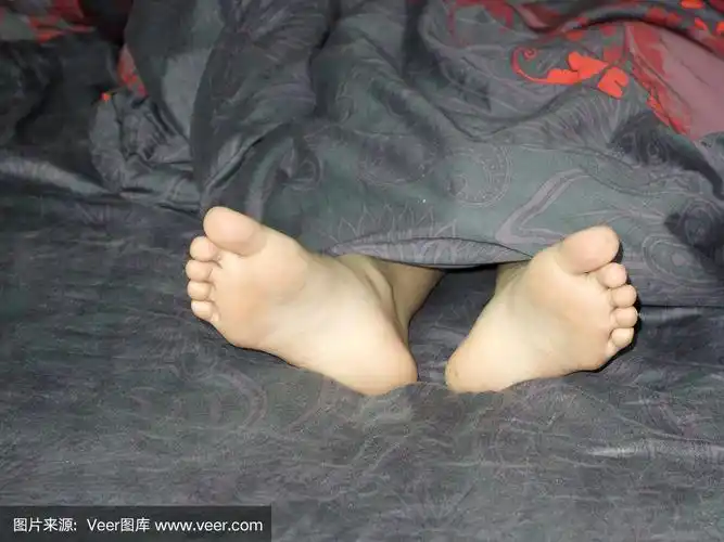 一个小女孩光着脚躺在彩色的床上