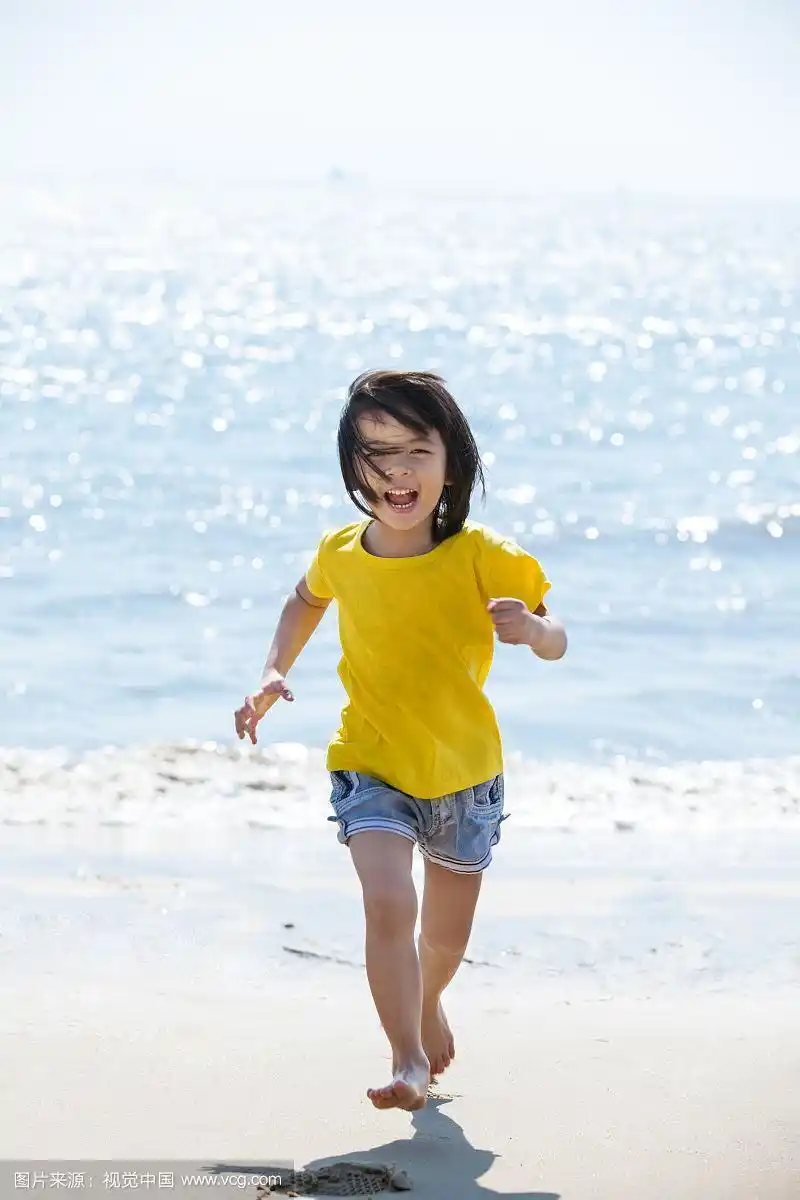 小女孩赤脚在沙滩上奔跑