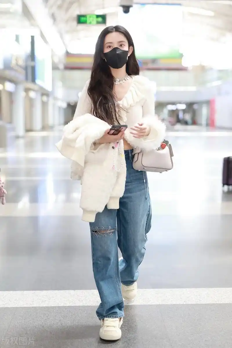 孟子义机场街拍,白色荷叶边针织衫搭配阔腿牛仔裤,白色运动鞋时髦复古