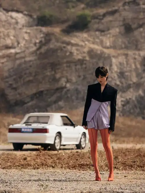 李宇春身穿西装外套,搭配网袜高跟鞋,红色,紫色与黑色的色彩撞击,在