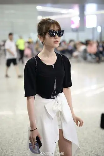 毛晓彤戴墨镜穿黑t恤搭配白短裤现身机场,把衣服绑在腰上很时髦