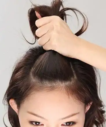 用梳子把头发梳顺,取出一小撮头顶部分的头发.