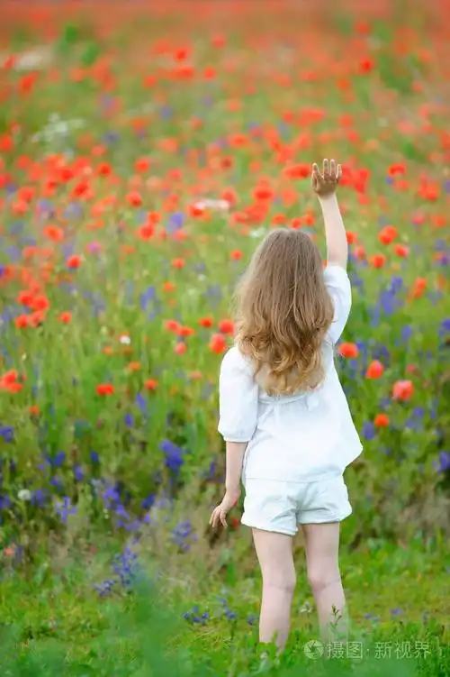 照片 可爱的小女孩与举起的手,到顶部.查看从背面.jpg