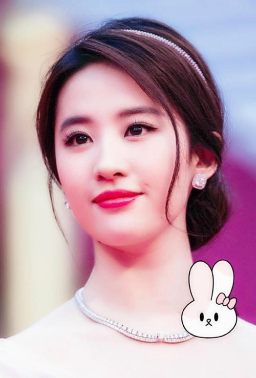 活动现场,刘亦菲穿着裸粉色的长礼服,脸上画着淡妆,在头发,脖子上还带