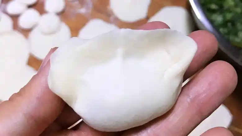 龙利鱼韭菜水饺,然后把两边都捏好,再用两只手挤成好看的大肚饺子