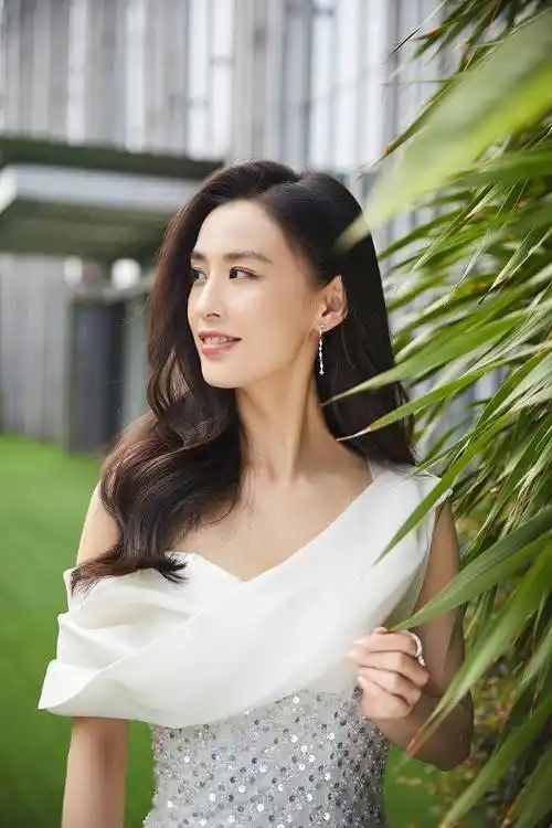 黄圣依草坪拍写真坐姿优雅迷人 大波浪配斜肩白裙高挑性感