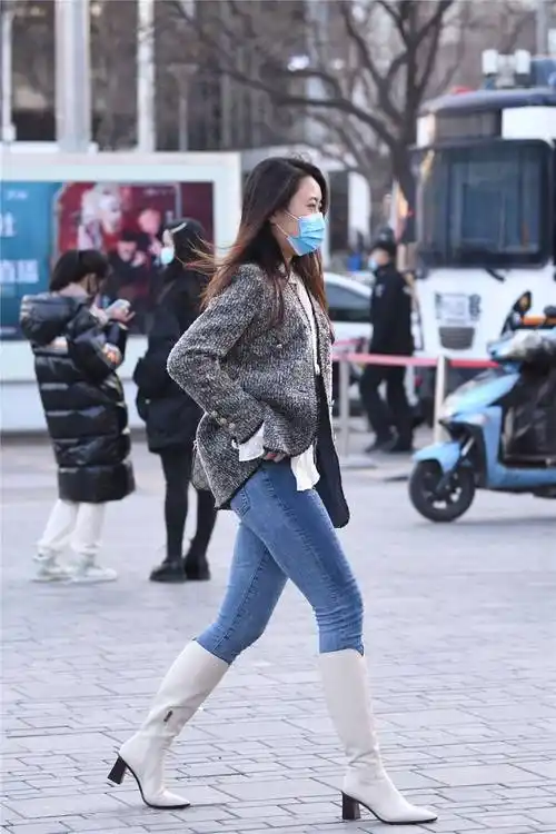 6厘米的粗跟长靴,白色靴筒和黑色粗跟设计,搭配蓝色的紧身牛仔裤_穿着