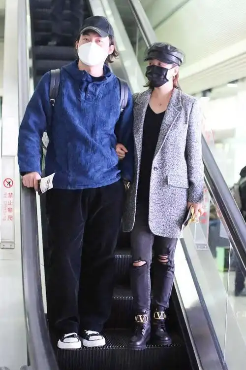 马丽携手丈夫到机场穿灰色呢外套搭破洞裤两口子很潮