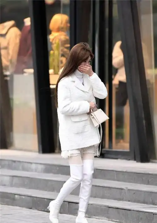 白色粗跟过膝靴搭配白色丝袜毛衣和外套都是白色的