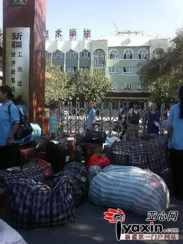 昌吉卫校的新生们托着重重的行李等候在新疆工业经济学校门口.