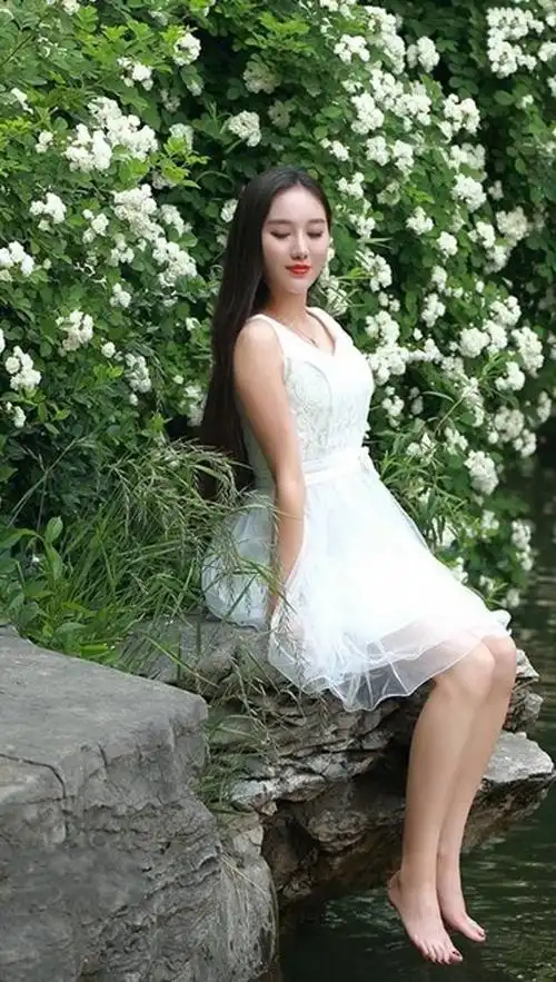 小姐姐皮肤白皙水嫩,身材丰腴,穿上白色吊带连衣裙美极了