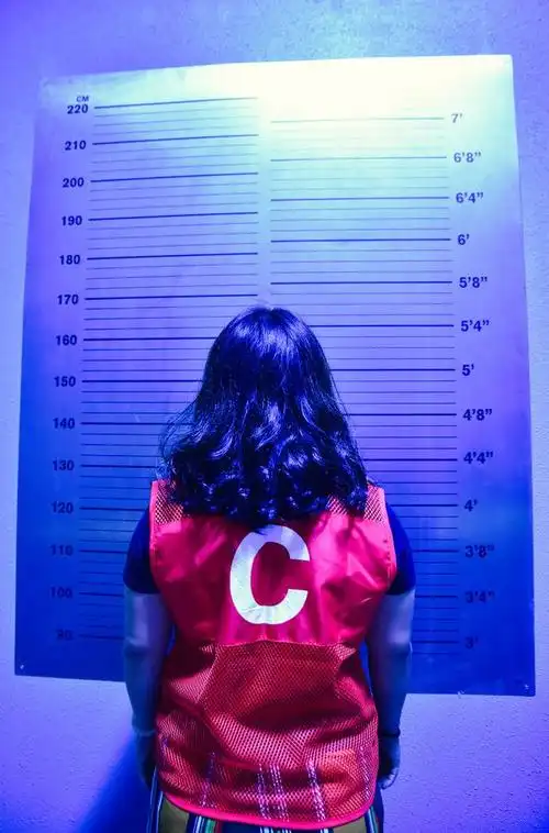 犯人首先会被带到一个房间,在一面标有身高的墙上拍几张正面,背面和