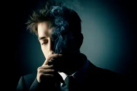 年轻英俊的时尚男人吸烟雪茄照片