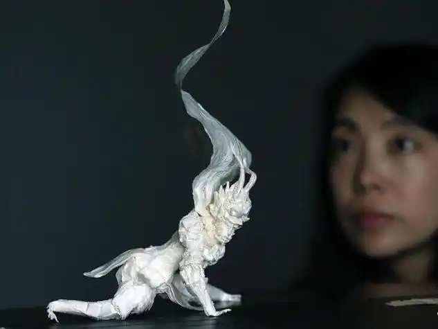 9月6日一位市民在欣赏秦坤的折纸作品大圣归来.