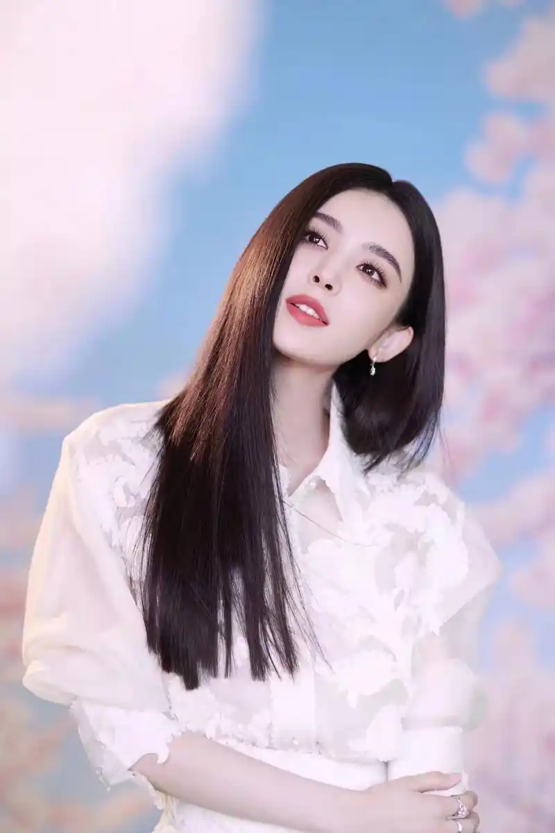 古力娜扎,身穿白衬衫,长发披肩,红唇微笑,眼神灵动,真是一位绝代佳人.