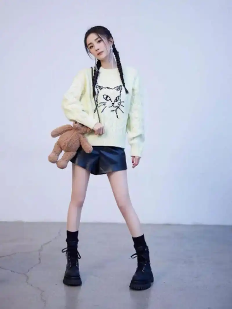 杨幂身高不算高,但是却很有气场,这件浅色针织毛衣搭配黑色皮革短裤