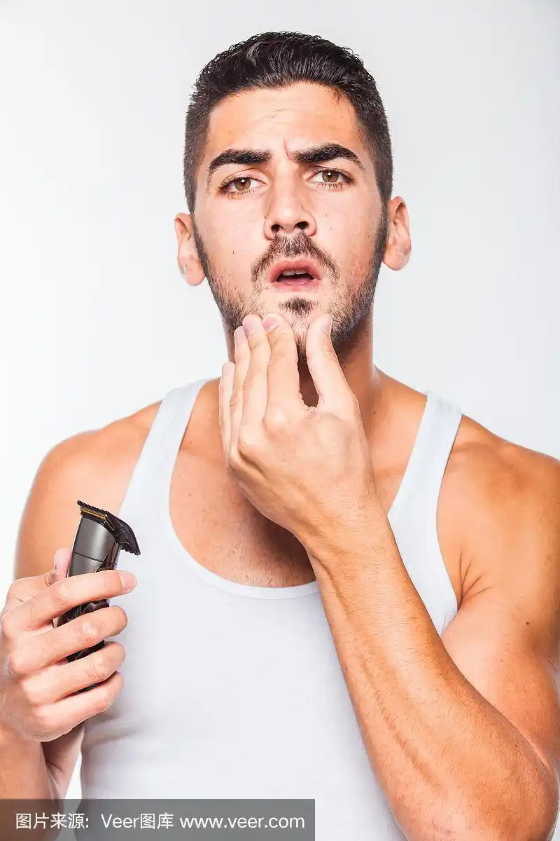 年轻英俊的男子正在修剪胡须
