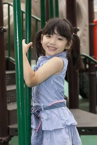 小女孩在幼儿园内玩滑梯