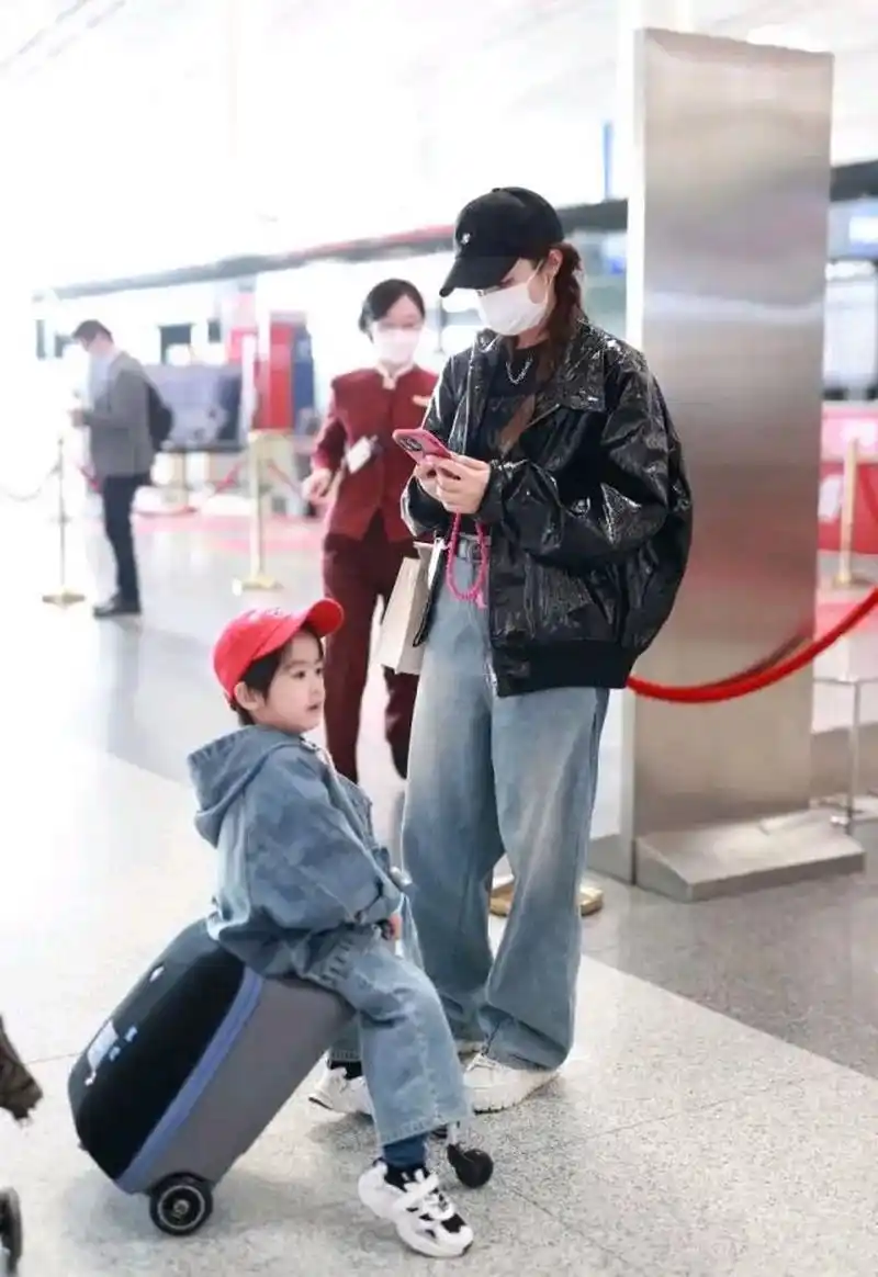 麦迪娜带着儿子姜丹尼尔亮相首都机场,她这次搭配的很有潮流感  里面