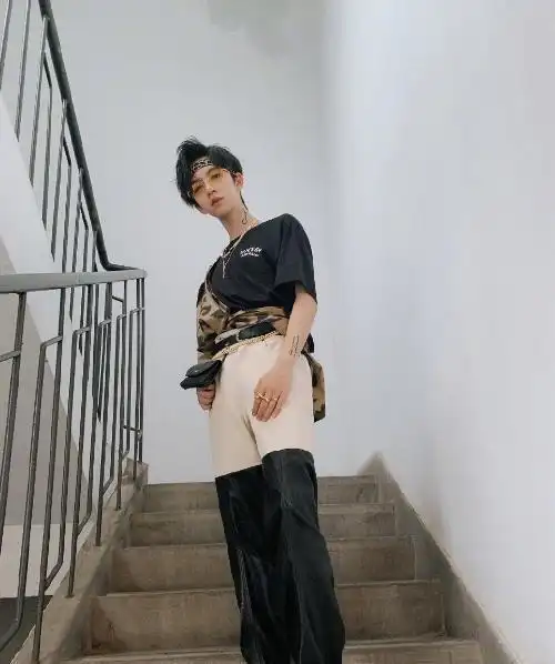 贺峻霖身穿黑色t打底外面配上豹纹衬衫,豹纹衬衫一边穿上一边绑在腰上