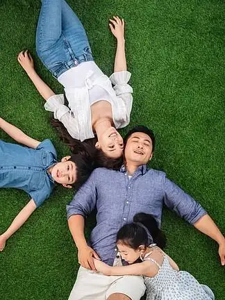 幸福的一家四口躺在草地上休息