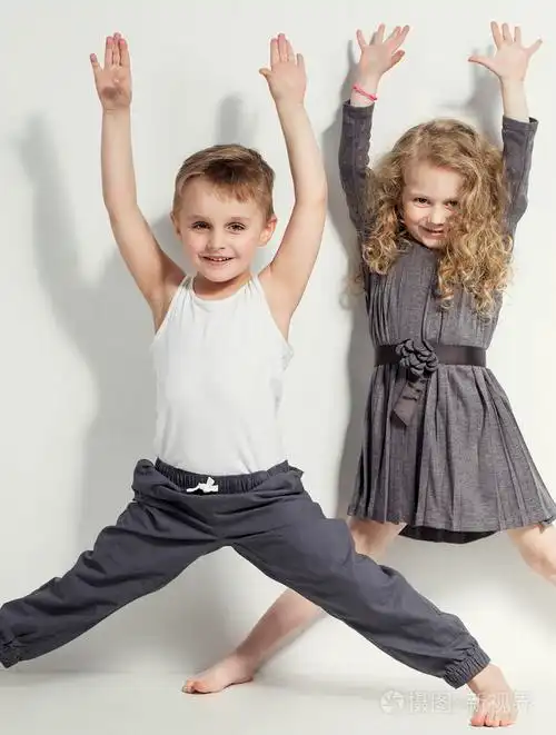 有趣可爱的孩子时尚的小男孩和女孩在灰色和白色的衣服光着脚以不同的