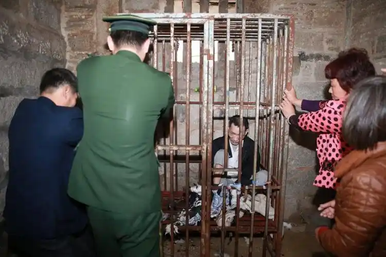 2014年2月18日,福建晋江,*关了10年的铁笼已经生锈,多人合力也拽不开.