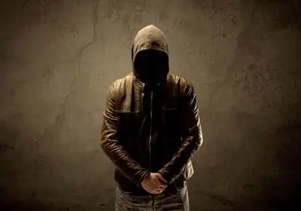 未知的蒙面电脑黑客神秘的蒙面人戴着黑色面具,手里拿着两个白色面具.