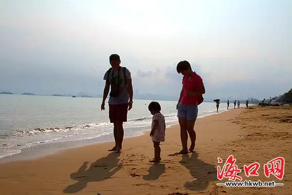 一家三口在海边踏浪嬉戏