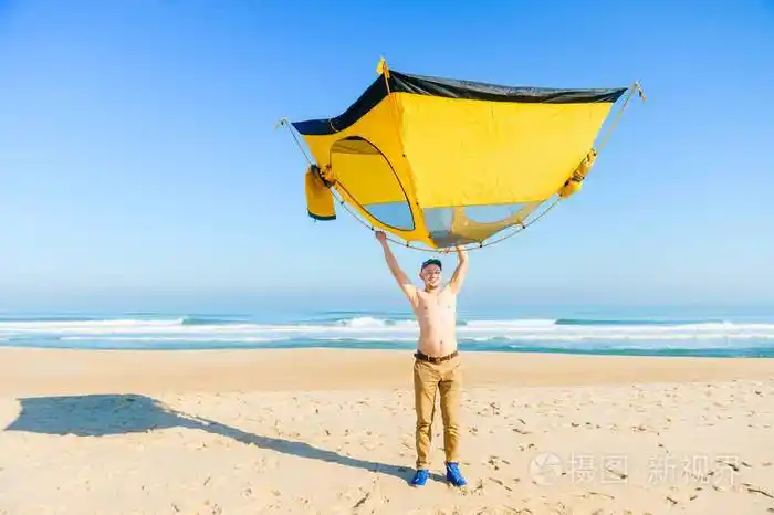 在葡萄牙大西洋附近的沙滩上顶着帐篷的裸体男子
