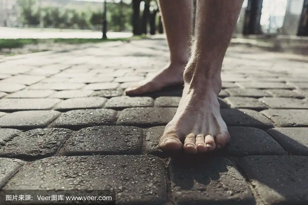 男人光着脚踩在人行道上