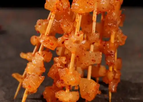 深色背景上摆放的牛筋烧烤食材肉串