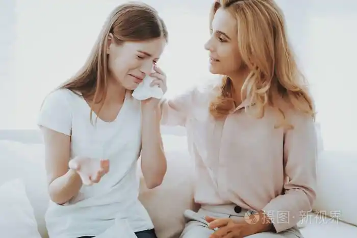 女人在家安慰不幸的十几岁的女儿坐在家里的沙发上有问题的女孩家庭