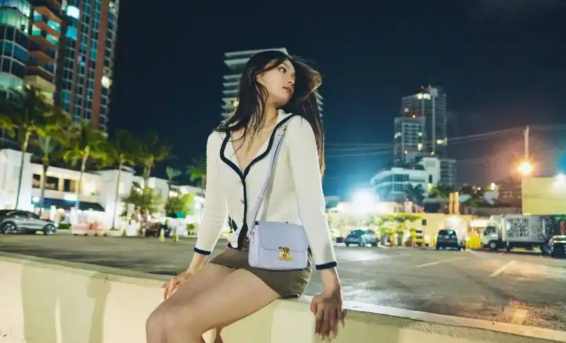 漫步在夜色中,林允的白色毛衣和棕色超短裙秀出了她的美腿,时尚女神范