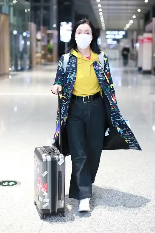 陶虹行程繁忙频现身机场黄卫衣露出红色衣领仿佛西红柿炒蛋