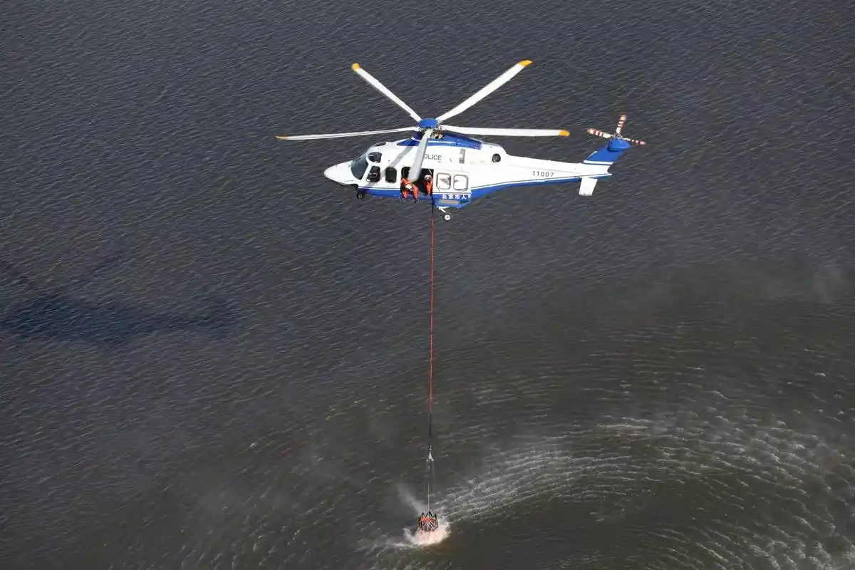 直升机吊挂消防水桶取水训练.来源:北京市人民政府航空队