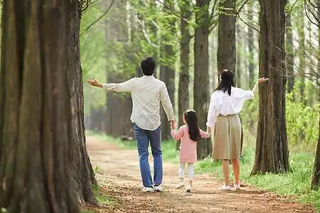 张开双臂小女孩背影公园里游玩的一家三口背影背景