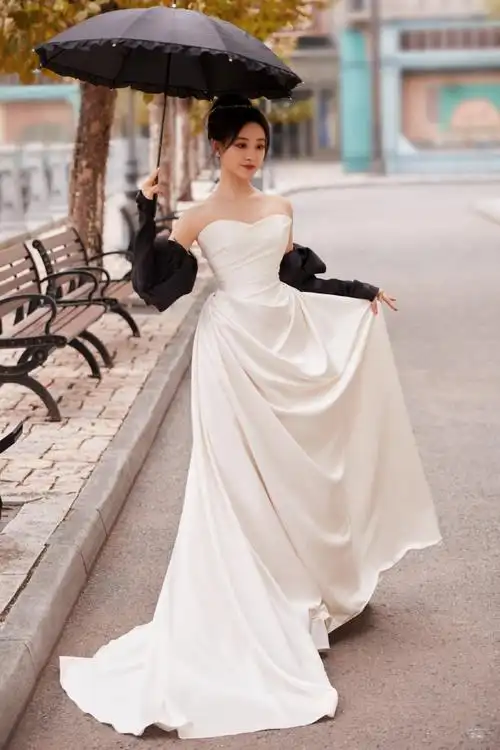 法国梧桐下,@祝绪丹bambi一袭白缎面墨色玫瑰礼服袅袅摇曳,漾开一抹