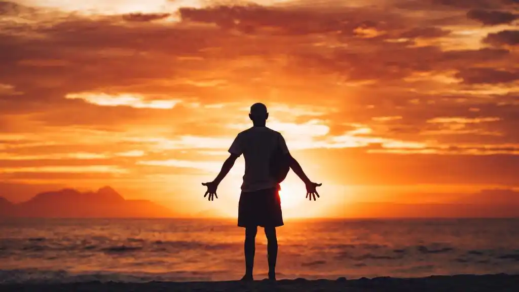 男人拥抱夕阳的背影