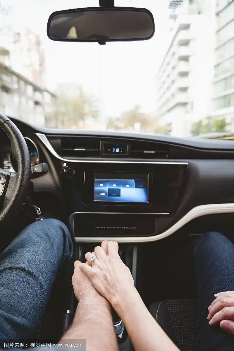 开车时手拉手的夫妇